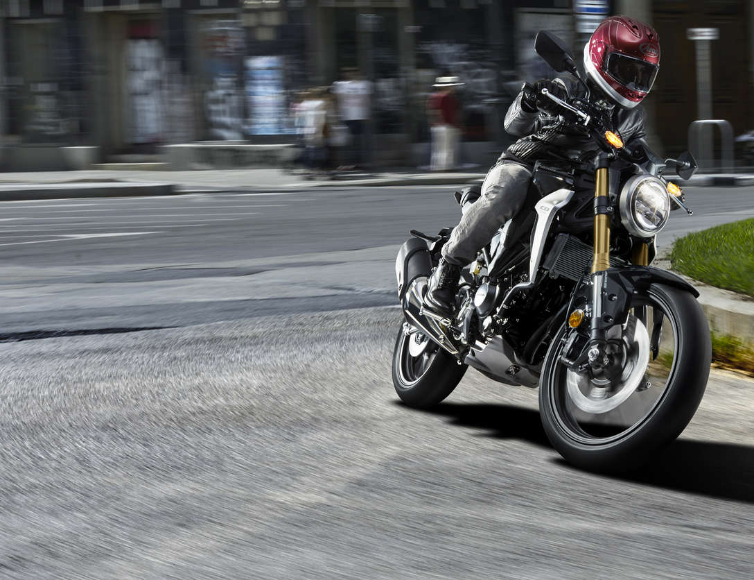 Vista frontale di tre quarti della Honda CB300R Neo Sports Café guidata su strada.