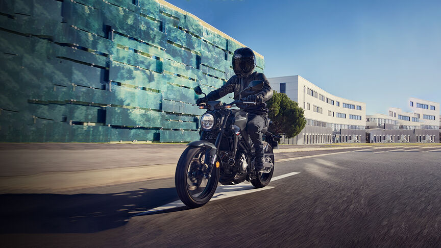 Vista anteriore di tre quarti della Honda CB300R ammirata da una donna in uno studio.