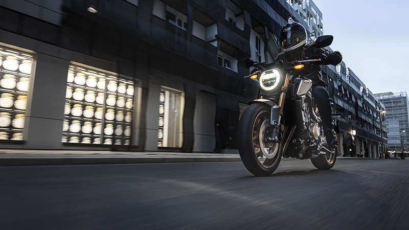CB650R Neo Sports Café, vista di 3/4 sinistra con guidatore, in ambiente urbano