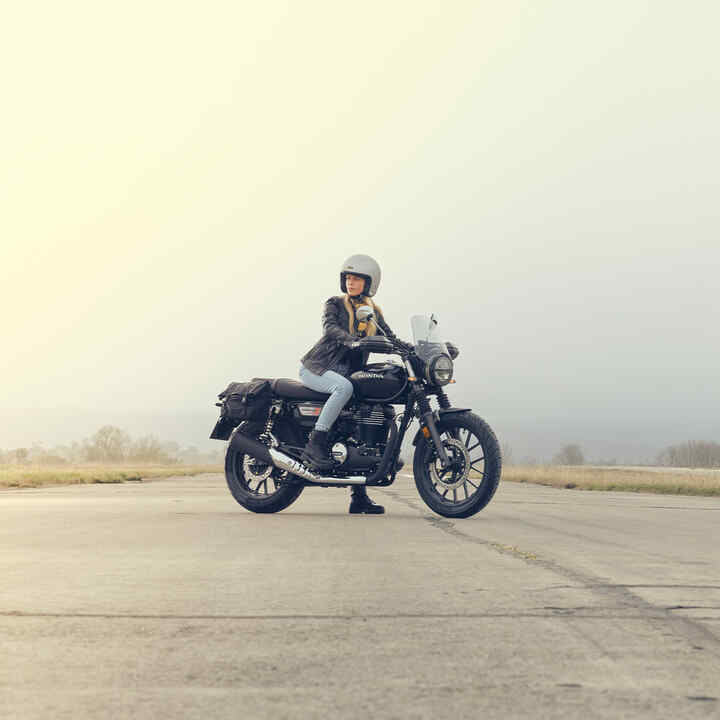 Vista laterale di GB350S sulla pista con un pilota donna