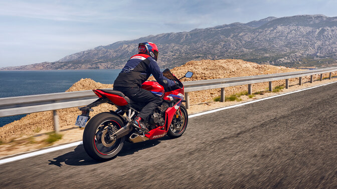 Vista posteriore di un pilota su una Honda CBR650R in strada. 