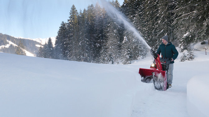 foto da lontano di uno spazzaneve utilizzato sulla neve alta