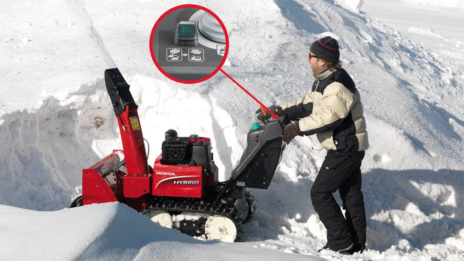 Spazzaneve ibrido utilizzato da un operatore con dettaglio sul pulsante di ripristino, sulla neve.