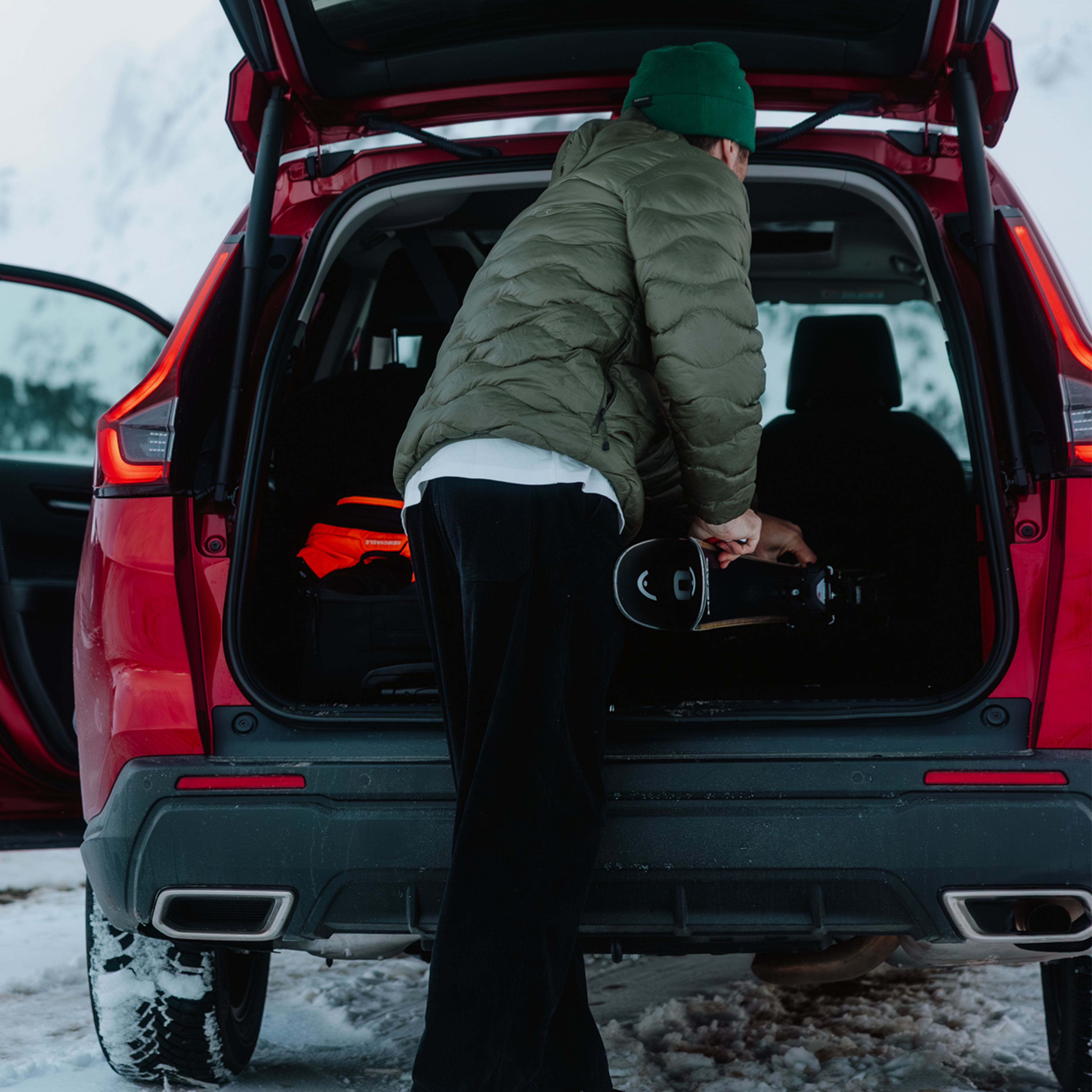 Una persona sta caricando gli sci nel bagagliaio della CR-V AWD.