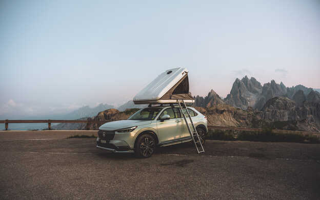 HR-V e:HEV Hybrid con una tenda da tetto e le Dolomiti sullo sfondo