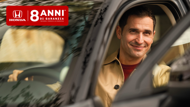 Uomo sorridente al volante di una Honda parcheggiata, con la portiera aperta e il logo “8 anni di garanzia”